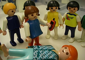 Playmobilfiguren stehen um eine liegende Figur in der Mitte